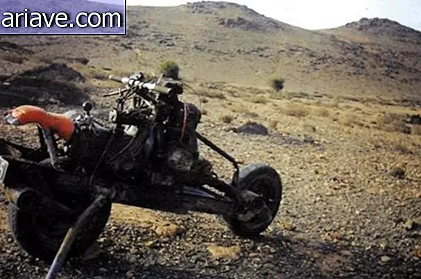 De verloren man in de woestijn bouwt motorfiets met gebroken autodelen